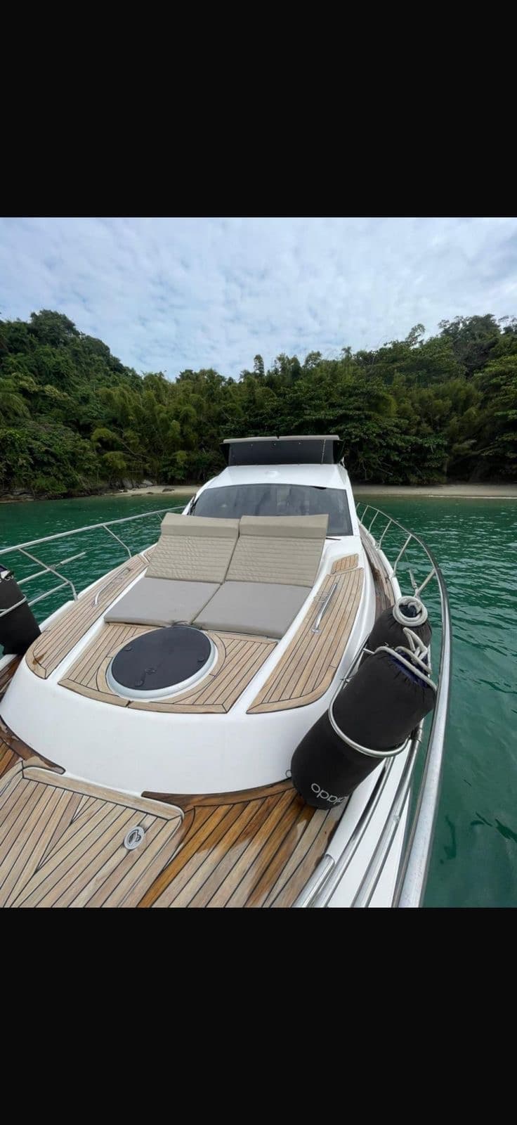 Solário de proa da Murmura Náutica com estofados claros e deck em teak